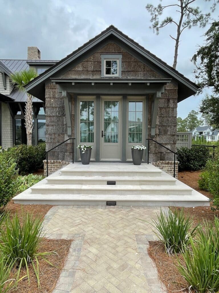 Front view of a cozy bungalow entrance surrounded by greenery in Bluffton, SC.