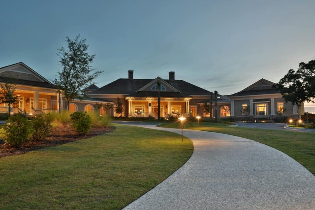 Elegant clubhouse with pathway on Hilton Head Island at twilight, capturing serene architectural beauty.