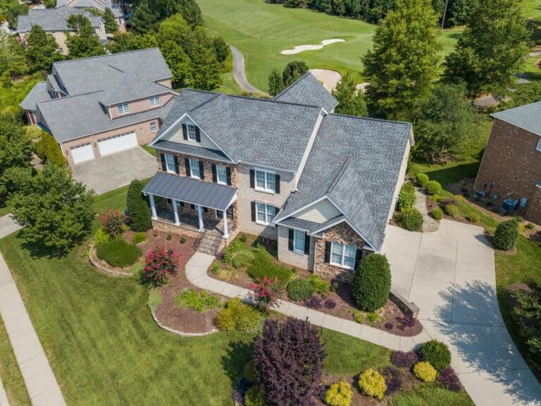 Bird's-eye view of a beautiful suburban home in Raleigh, NC, with lush landscaping.
